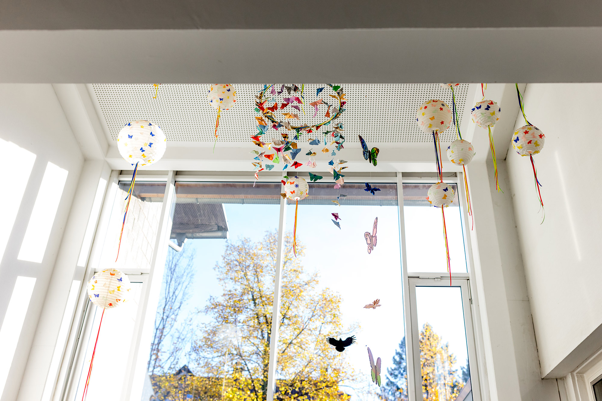 Bunte Dekoration hängt im Flur der Grundschule Kippenheim vor großen Fenstern
