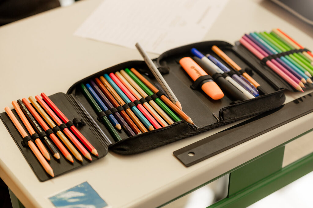 Buntstifte und Materialien liegen auf einem Tisch