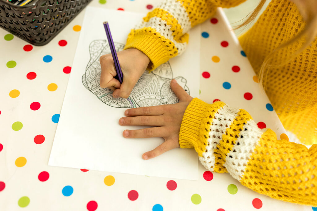 Kind malt mit einem Stift auf Papier