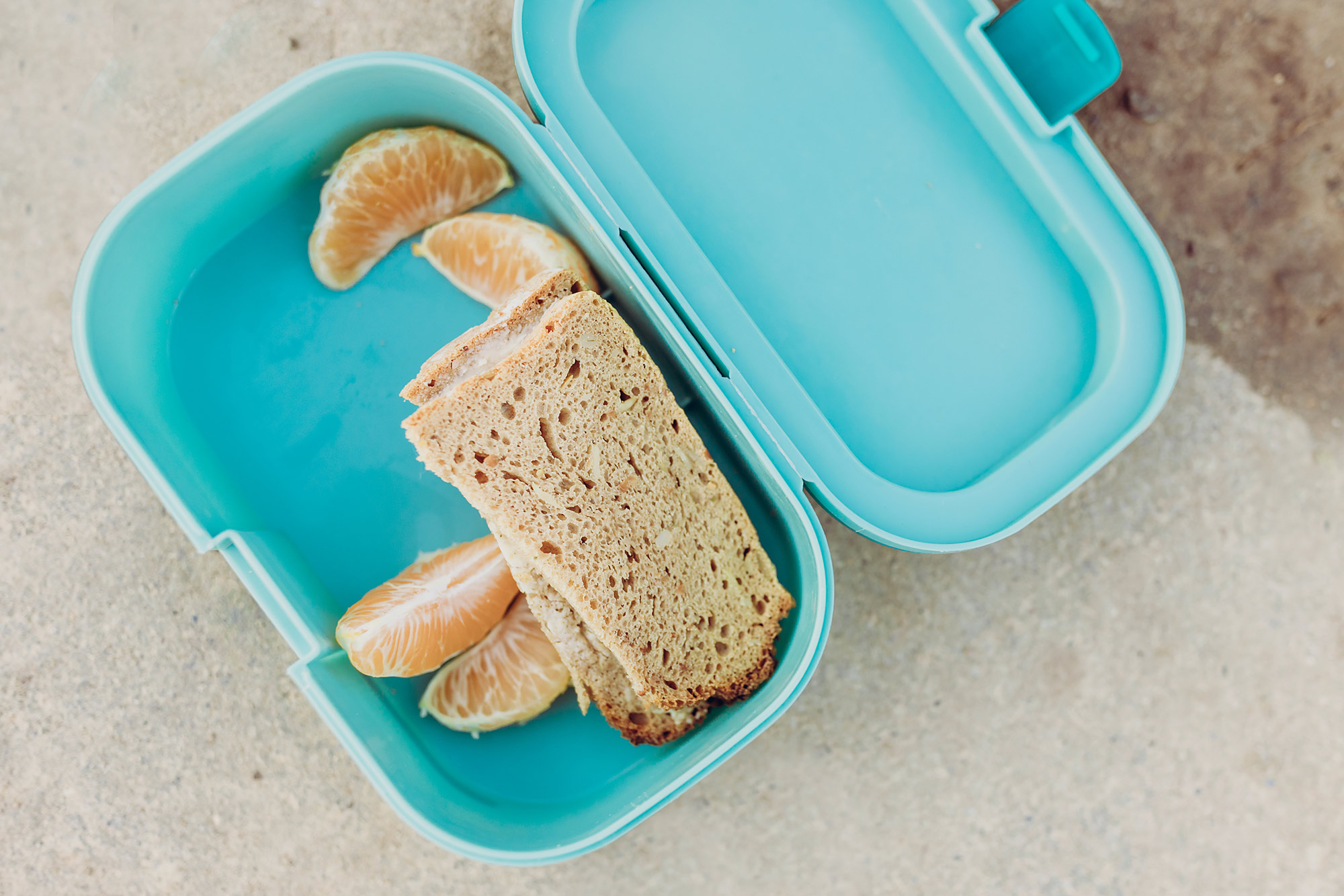 Brotdose mit belegtem Brot auf einem Tisch