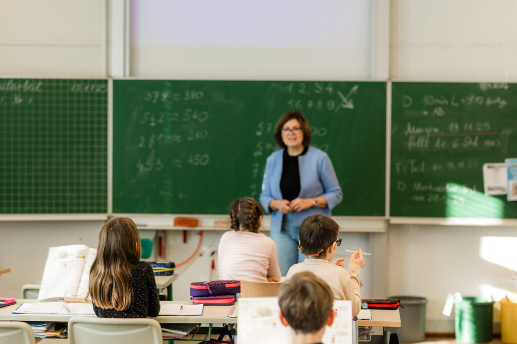 Kinder sitzen im Klassenzimmer und folgen dem Unterricht